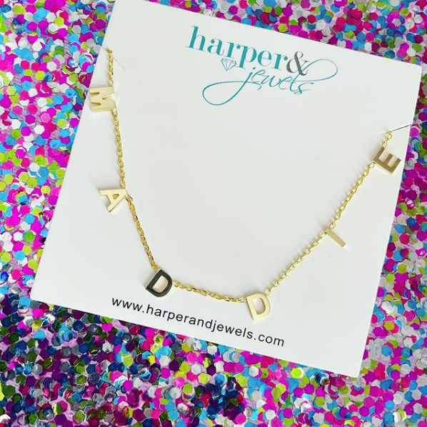 Maddie dainty hanging name necklace on confetti glitter background