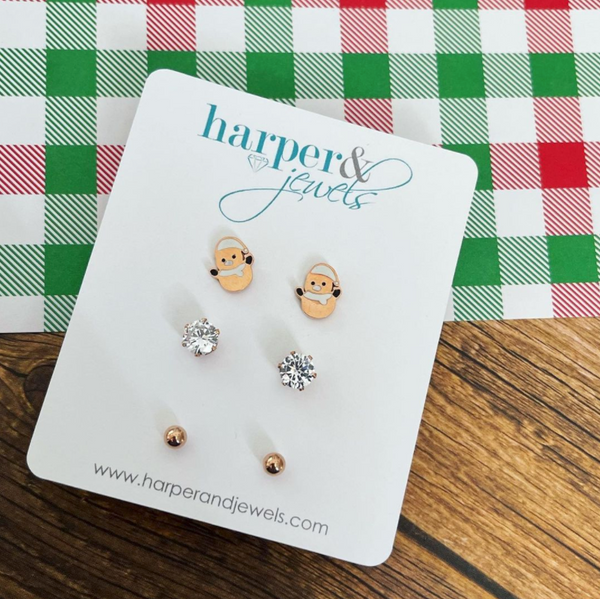 This is an image of our snowman 3 set stud earrings on red and white plaid background