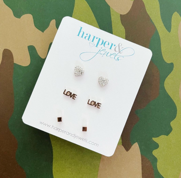This is an image of our love stud earring 3 piece set on a camo background
