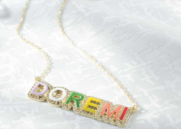 This is an image of our gold rainbow nameplate necklace on a white background