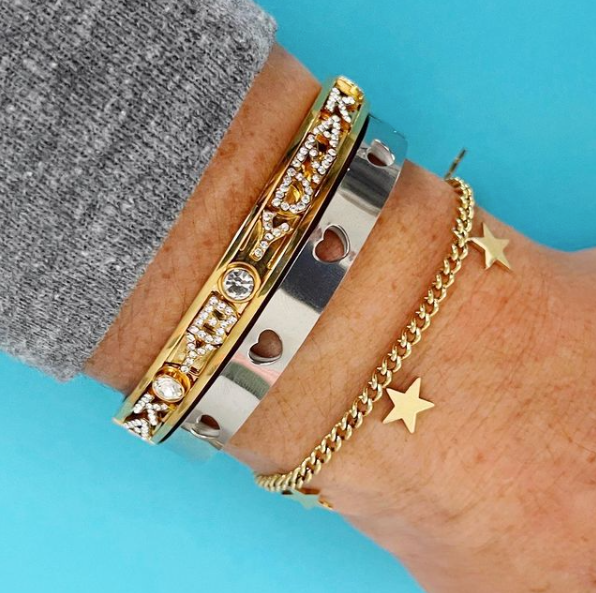 this is an image of an arm party featuring our hanging star charm bracelet, heart punch, and sliding charm bracelets.