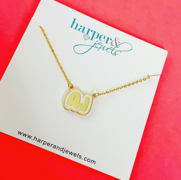 This is an image of our bubble letter nameplate necklace with the initials AJ on a white background