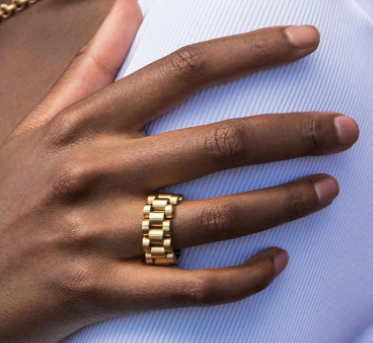 This is an image of our gold watchband-style ring on a models hand