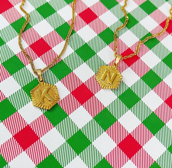 Rectangle medallion letter necklaces on a red and green plaid background
