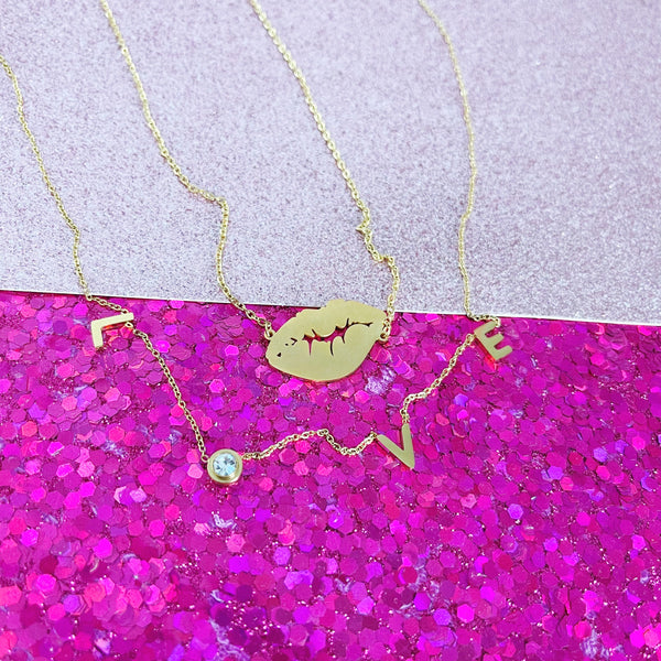 Lips with love necklaces on pink glitter background