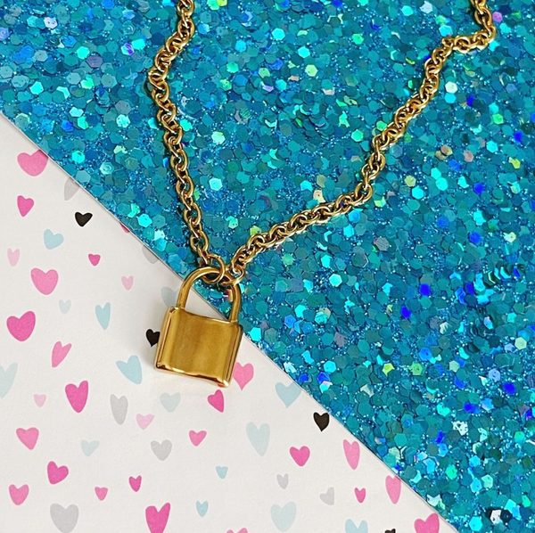 lock pendant necklace on blue glitter and heart background