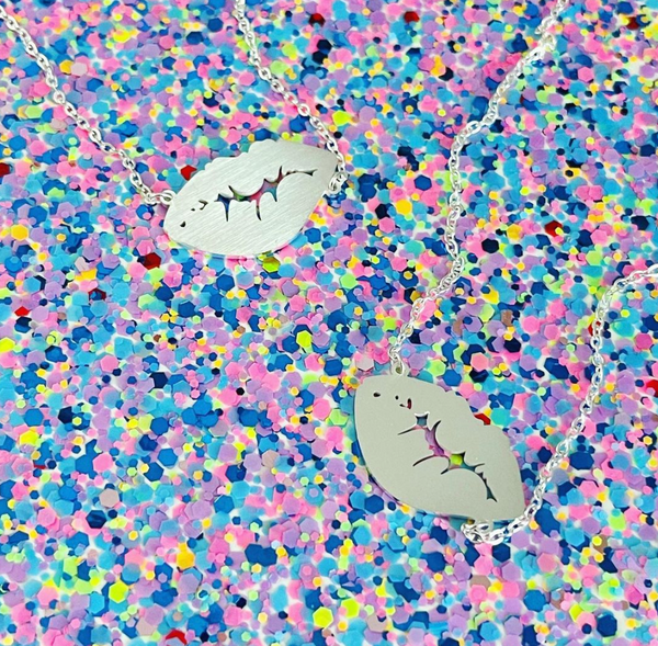Silver lipkiss necklaces on a glitter background