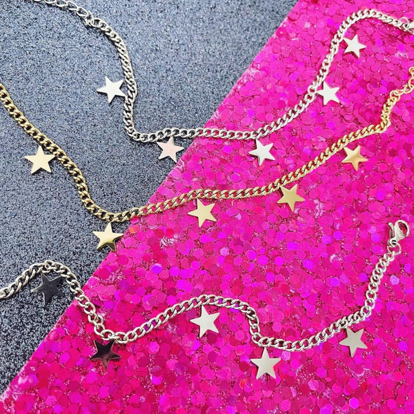 This is an image of our star charm bracelets on a pink and blue glitter background