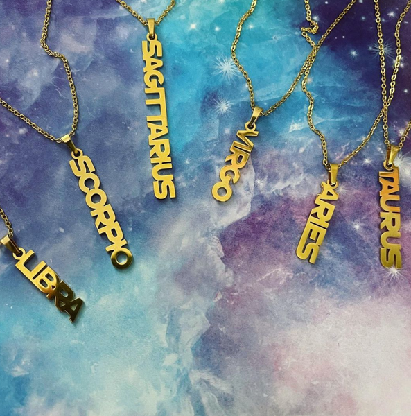 This is an image of our zodiac nameplate necklaces on galaxy print background